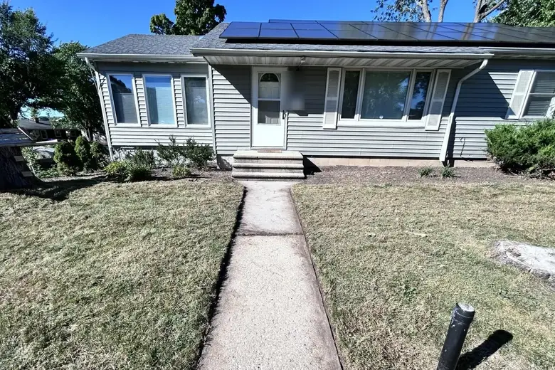 A front lawn, just mowed, with a straight edged walk to the door